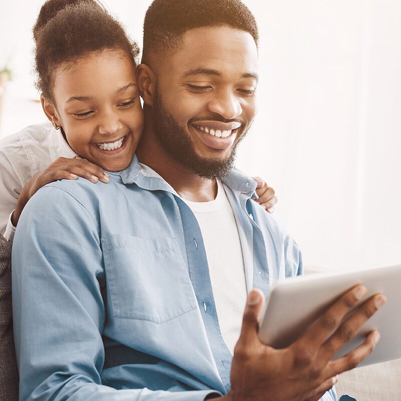 Father and daughter having video call on tablet