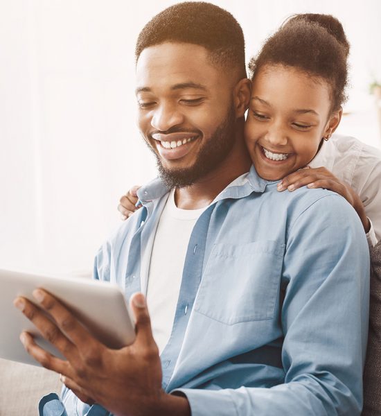 Father and daughter having video call on tablet